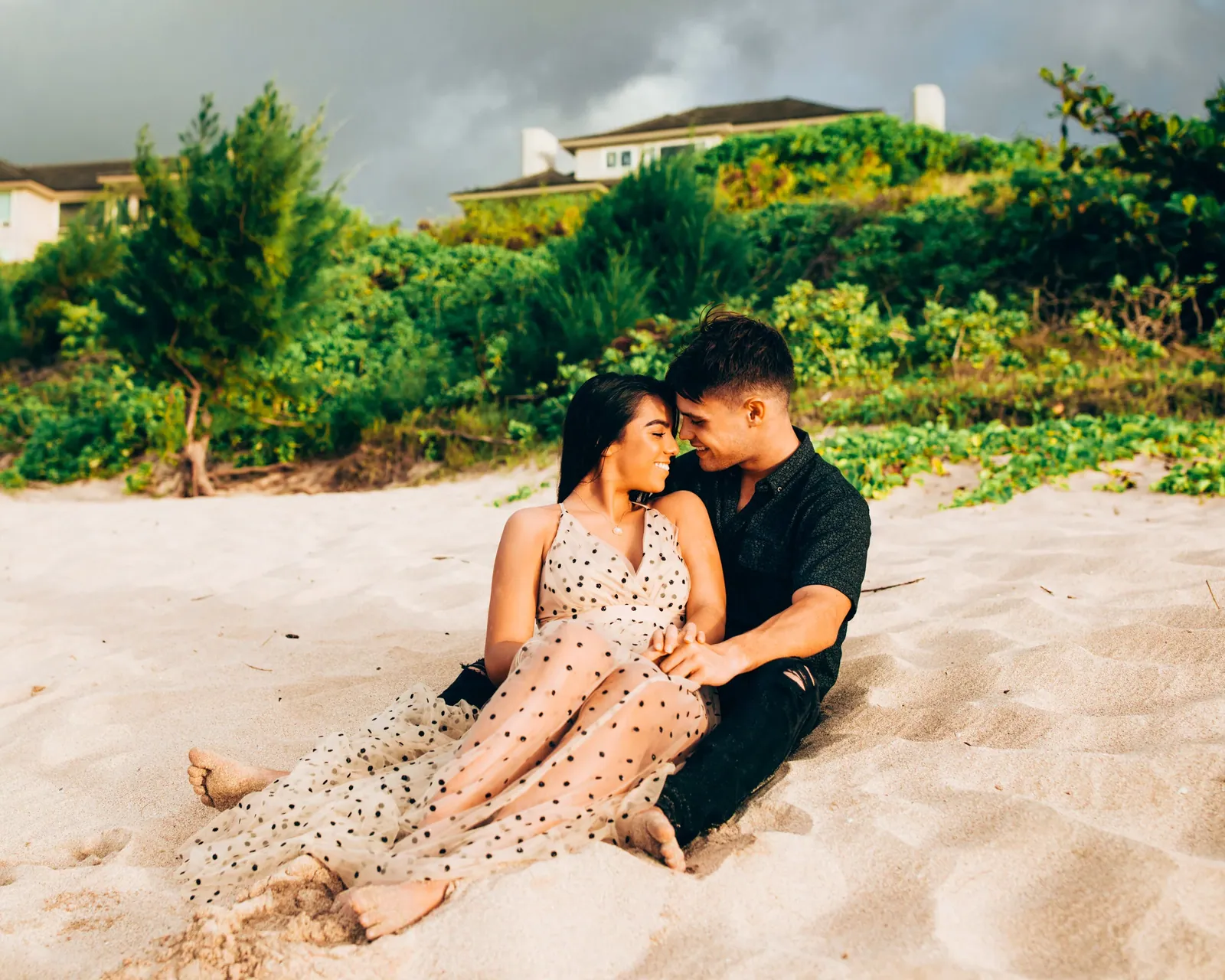 Couple sitting close on the sand during a relaxed Maui beach session