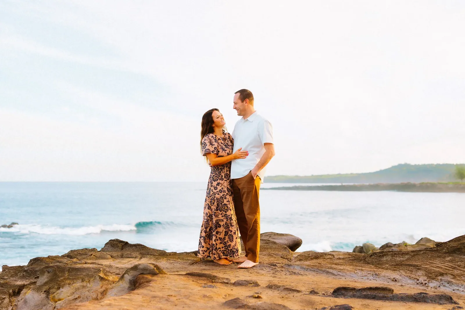 Couple on a sea-cliff lookout with the open ocean behind them, West Maui