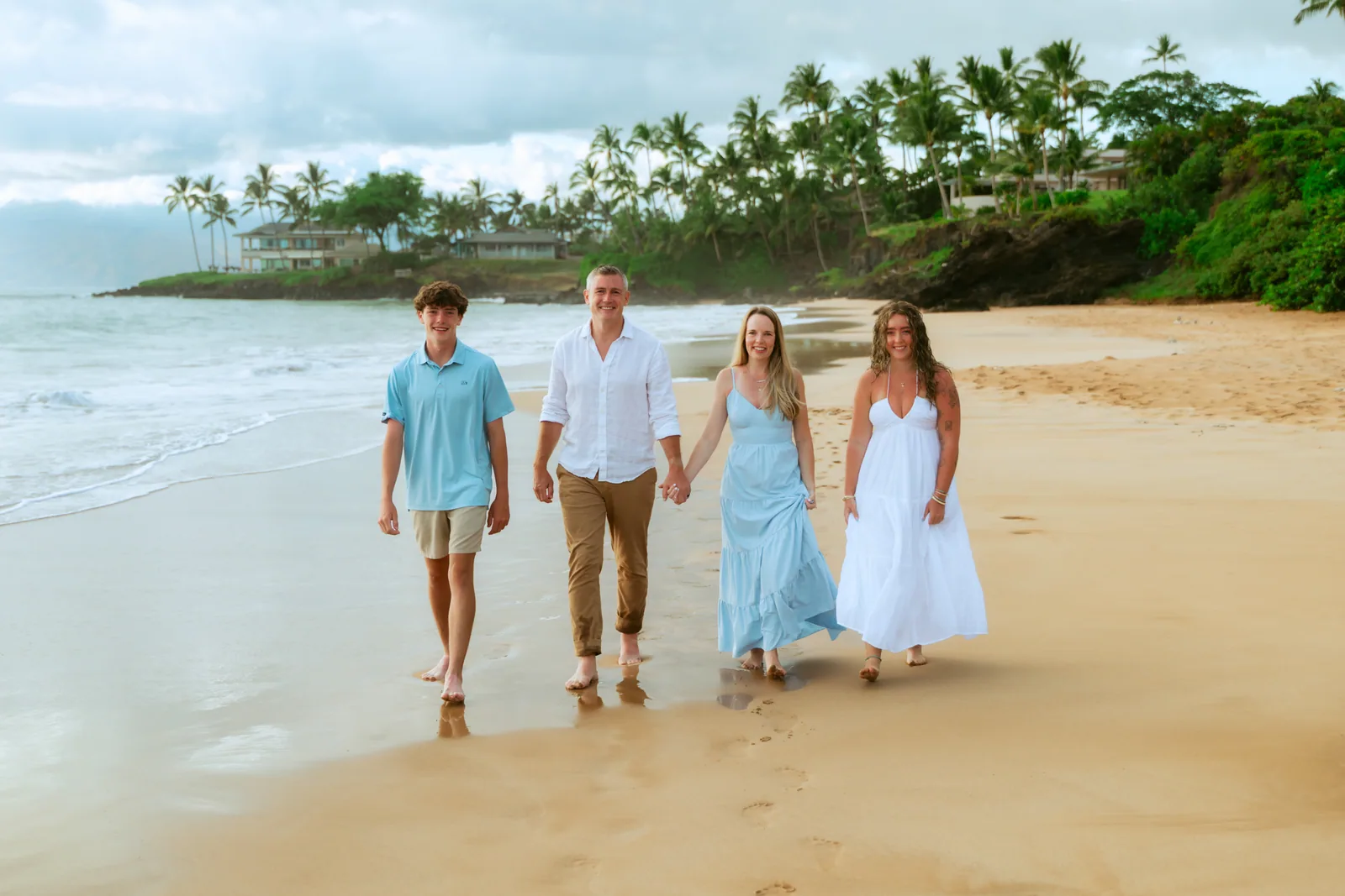 A family of five walking the shoreline together at golden hour