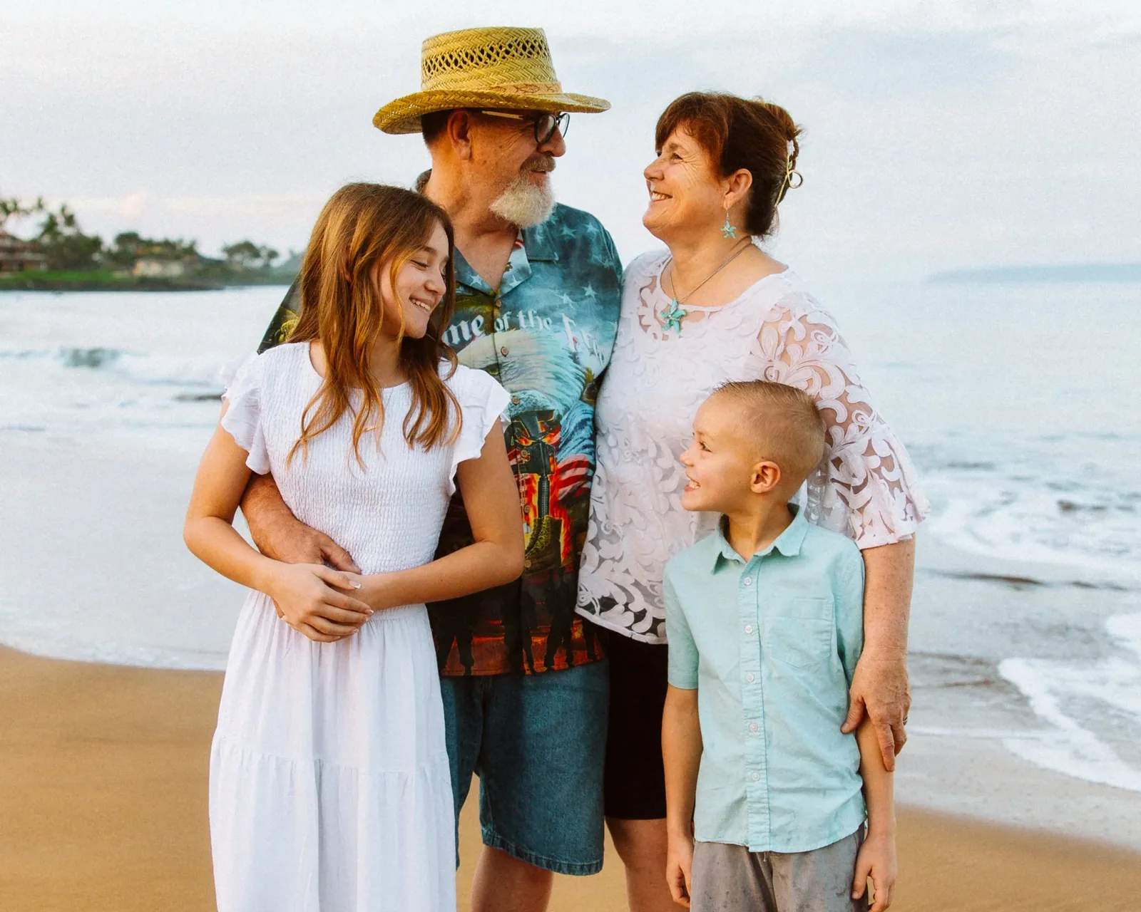 Multi-generational family standing together on the sand at a Maui beach