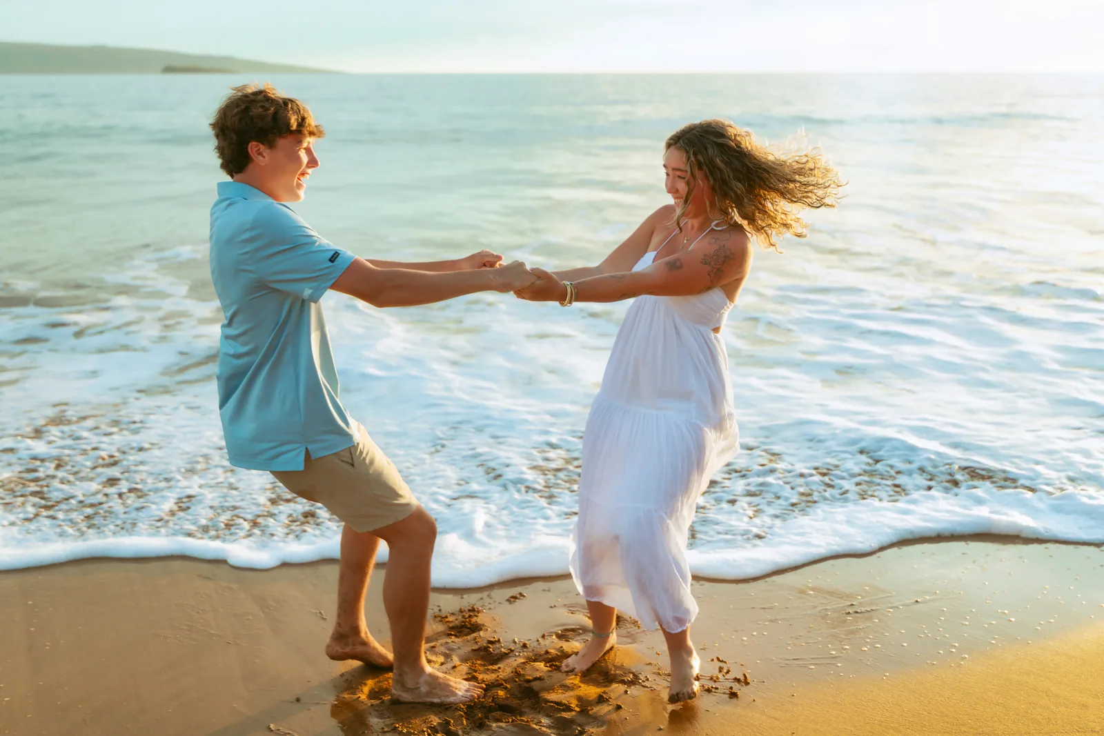 Parents swinging their daughter between them in the shorebreak