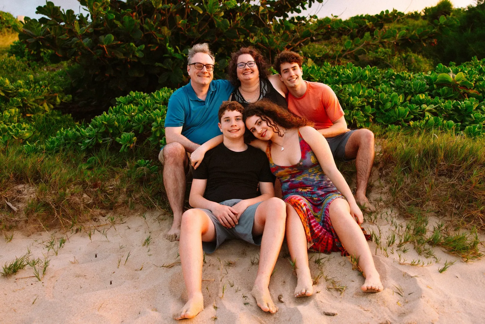 Family seated together on the rocks above a South Maui beach