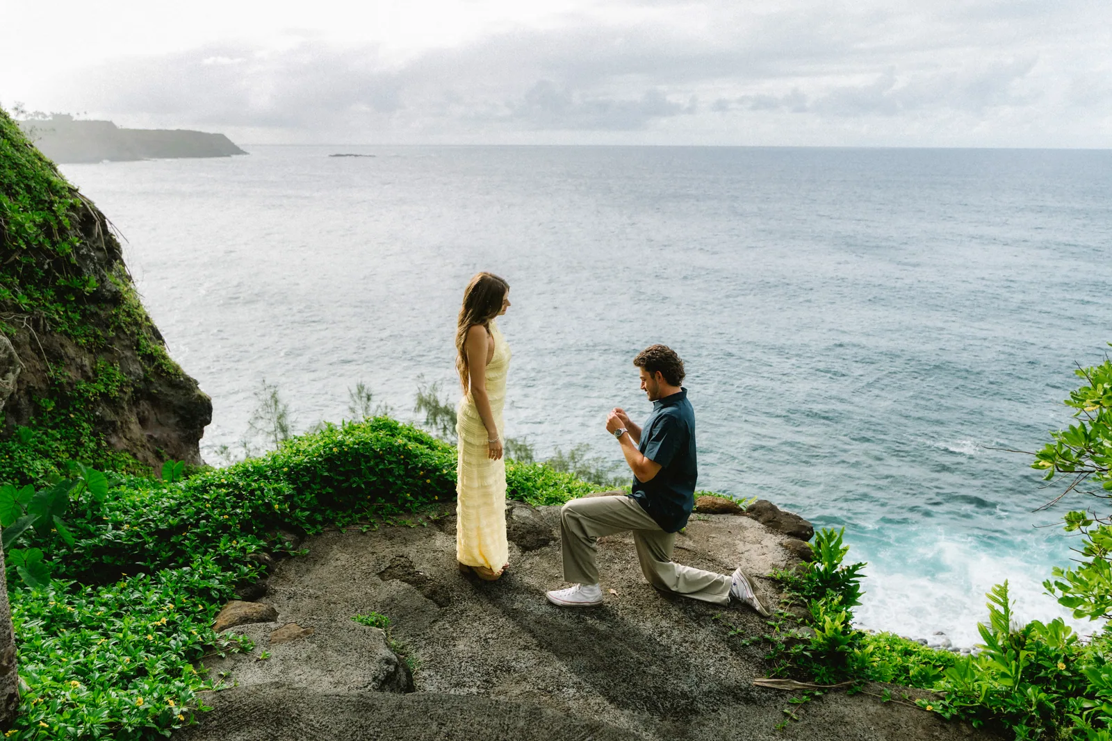 A proposal on a sea cliff photographed from a distance, him on one knee
