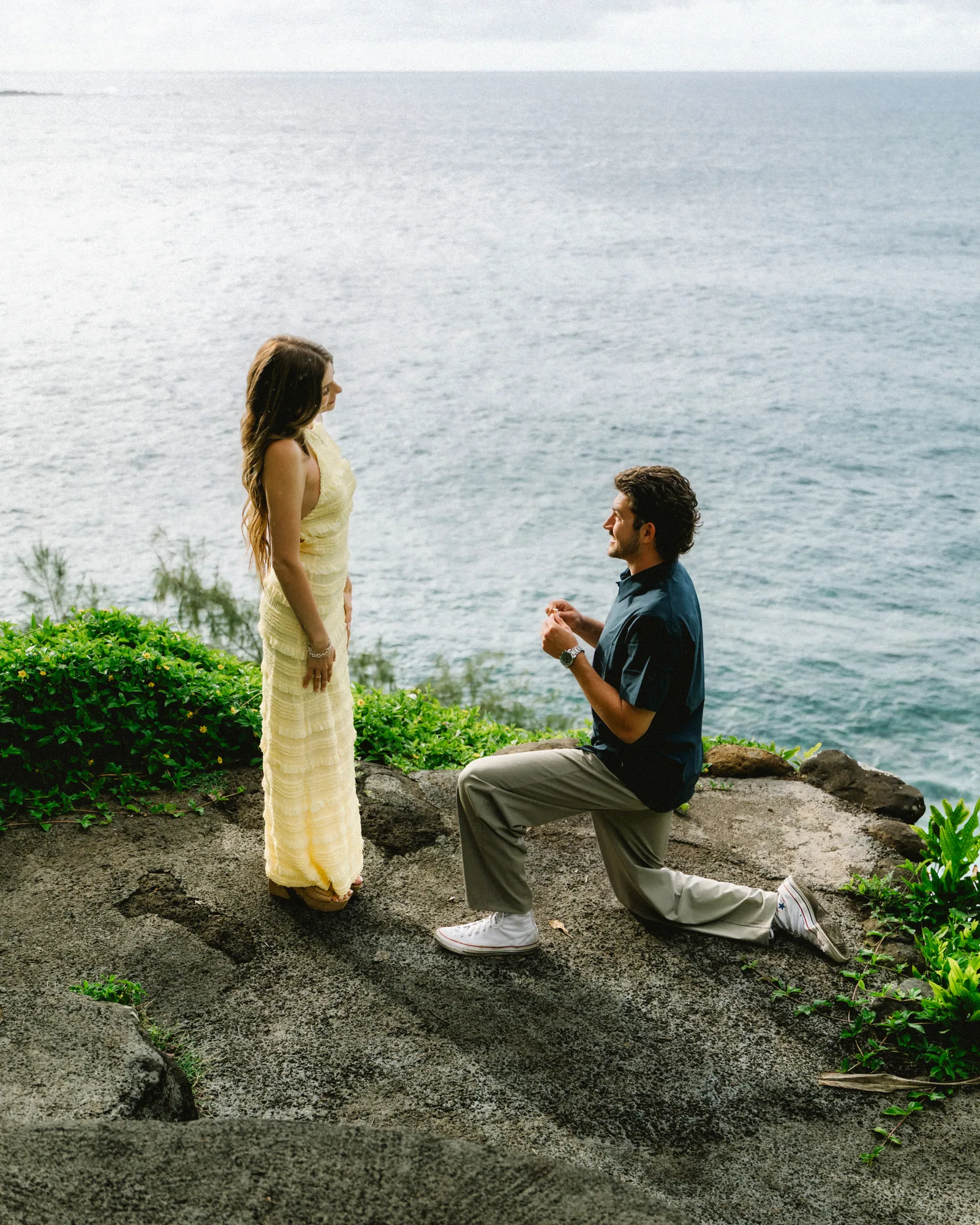 A proposal on a grassy sea cliff, her in a long yellow dress