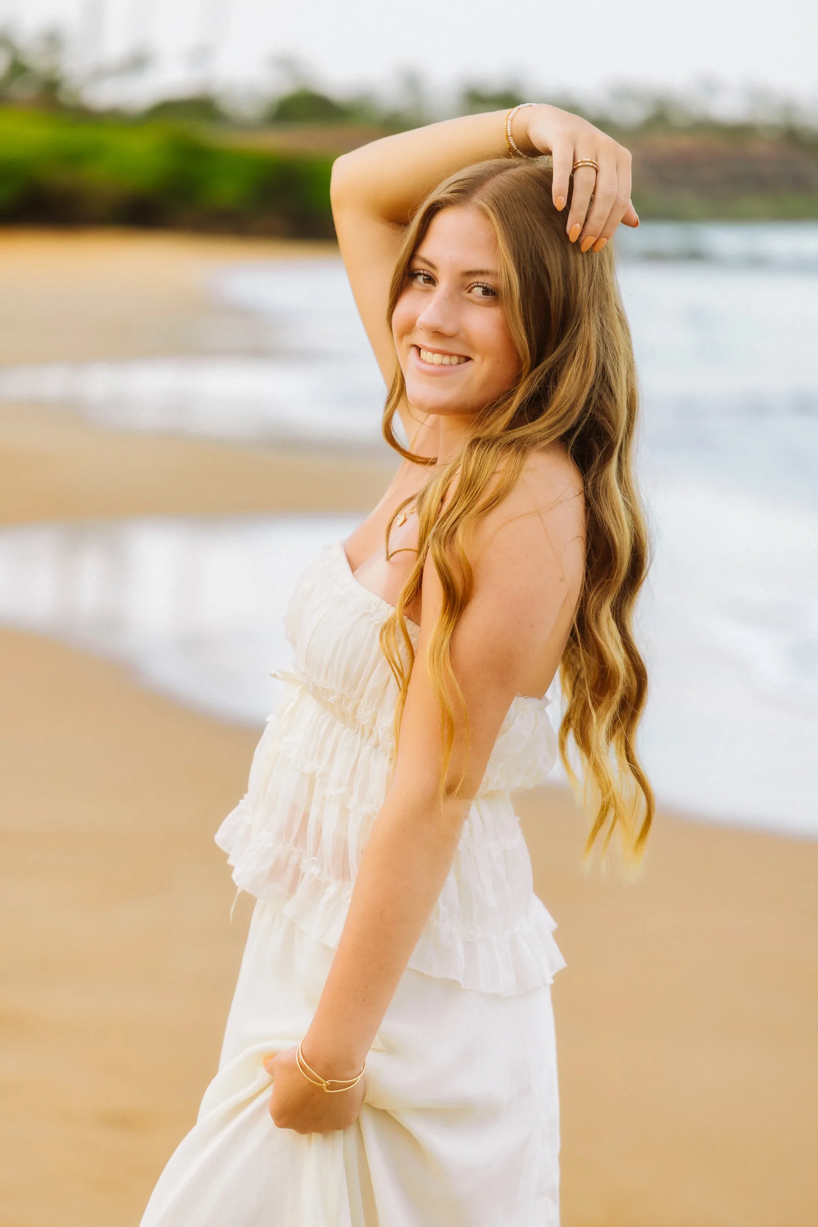 A senior portrait on the beach in warm golden-hour light